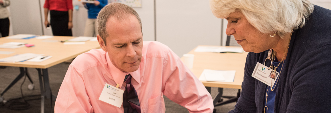 Man and Women Talking at Desk | Virginia Mason Institute