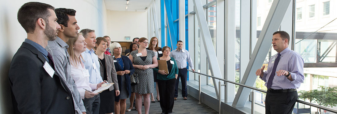 Speaker Talking to Group in Hallway | Virginia Mason Institute