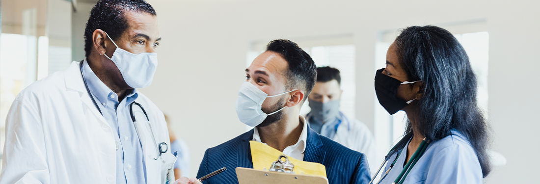 Two medical professionals with a patient wearing masks in clinic | Virginia Mason Institute